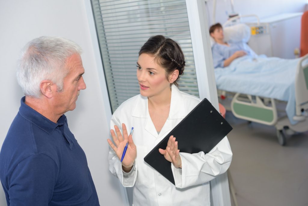 Nurse talking to family member outside of patient's room