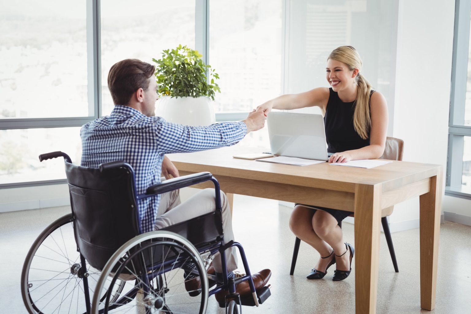 Smiling executives shaking hands at desk