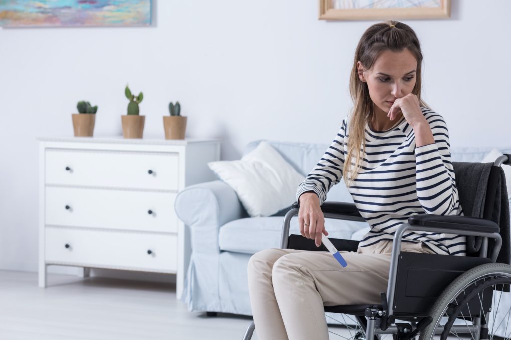 Women on wheelchair with pregnancy test